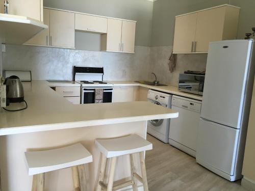 a kitchen with white cabinets and a white refrigerator at Ocean view, Swakopmund, 3-bedroomed apartment in Swakopmund