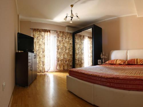a bedroom with a bed and a television in it at Villa Palma Ceoce in Budva