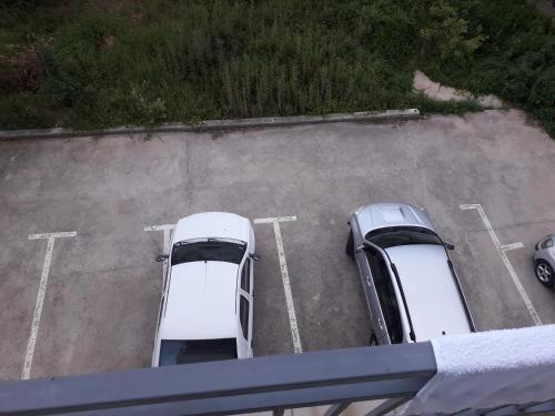 2 voitures blanches garées sur un parking dans l'établissement Apartman "Vienna", à Sokobanja