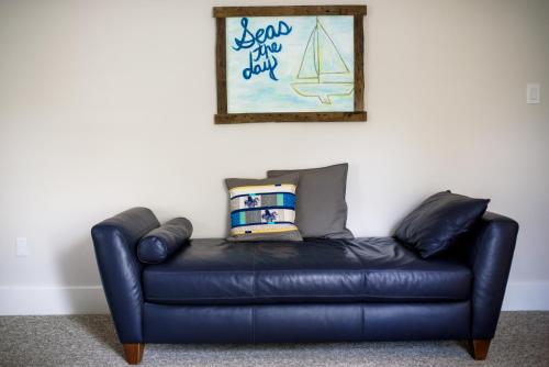 a black leather couch against a wall with a picture at The Kitch'inn - Boutique Inn and Wine Bar in Mahone Bay