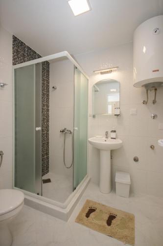 a bathroom with a shower and a sink and a toilet at Apartments Val Maslina in Utjeha