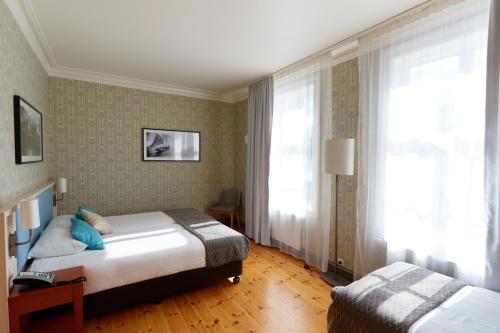 a hotel room with two beds and a window at Fosshotel Eastfjords in Fáskrúðsfjörður