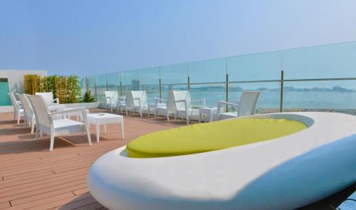 a bath tub on a balcony with chairs and tables at Hotel Presidente Luanda in Luanda