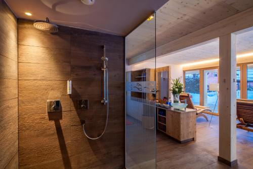 bagno con doccia e porta in vetro di Das Hotel Eden - Das Aktiv- & Wohlfühlhotel in Tirol auf 1200m Höhe a Seefeld in Tirol
