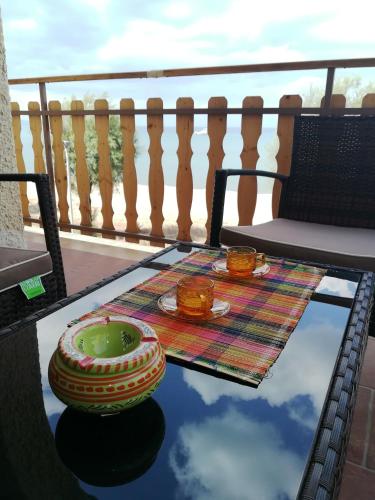 a table with bowls and plates on a balcony at Noemi Holiday House in Agnone Bagni