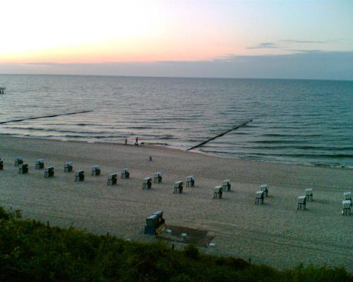 a group of chairs on the beach at sunset at Fewo am Strand in Koserow - Casa del Mar - 42m bis zum Strand in Ostseebad Koserow