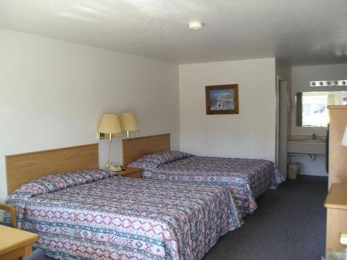 a hotel room with two beds and a table at Dude & Roundup in West Yellowstone