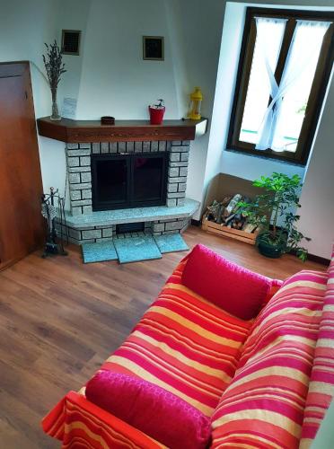 a living room with a couch in front of a fireplace at Casa Margherita Top in Sorico