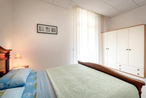 a white bedroom with a bed and a window at Residence Daniele in Bellaria-Igea Marina