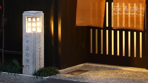 a light on a pillar in front of a building at Machiya Kaemon in Kyoto