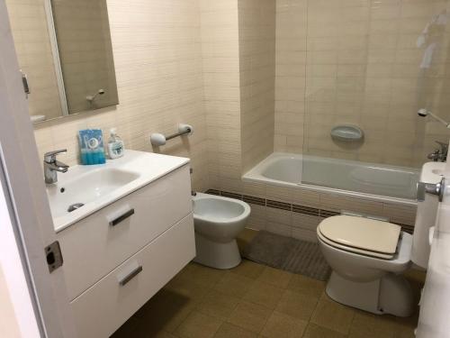 Un baño con lavabo, inodoro y bañera. en Llevant - Vistas espectaculares, en Sant Pol de Mar