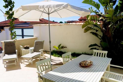 a table and chairs with an umbrella on a patio at The Enlightened Turtle in Agnone Bagni