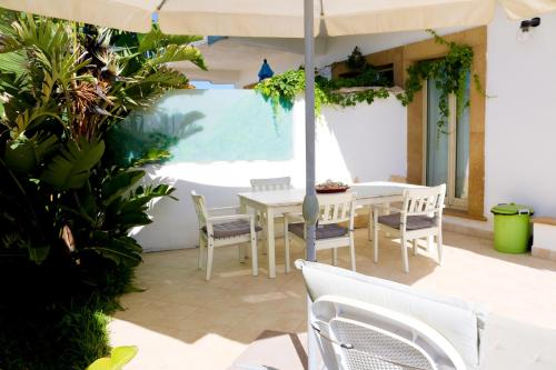 a patio with a table and chairs and an umbrella at The Enlightened Turtle in Agnone Bagni
