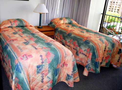 Cette chambre comprend 2 lits et une fenêtre. dans l'établissement Waikiki Sunset Apartment, à Honolulu