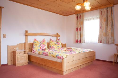 sypialnia z drewnianym łóżkiem i oknem w obiekcie Eggerhof - Ferienhaus w mieście Ramsau am Dachstein