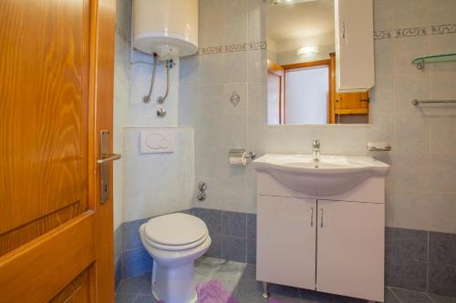 a bathroom with a white toilet and a sink at Apartment Rialto with private parking in Cres