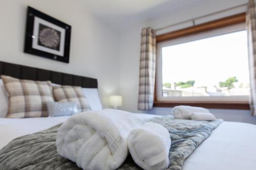 a bedroom with a bed with towels on it at Leys Park Executive Apartments in Dunfermline