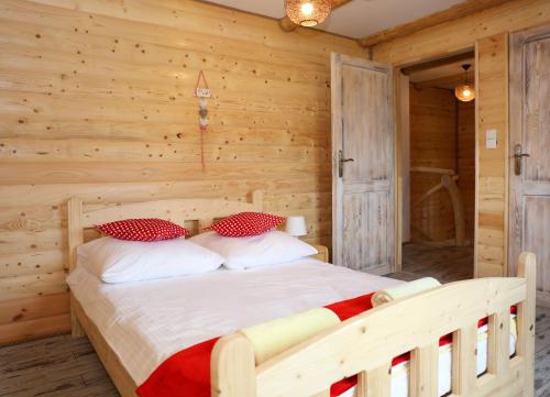 a bedroom with a bed in a wooden room at Chata Kukuryku in Baligród