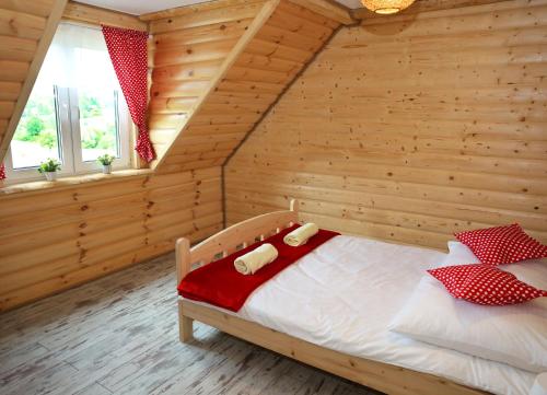 a bedroom with a bed in a wooden room at Chata Kukuryku in Baligród