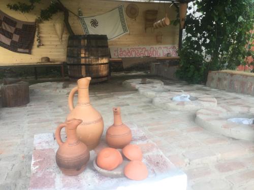 a group of clay vases sitting on a patio at Lazuri Keria Family Guesthouse in Khoni