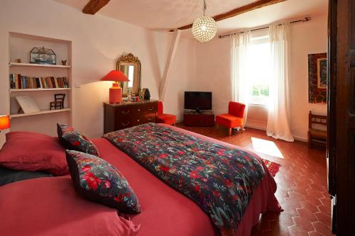 a bedroom with a red bed and a red couch at La Grande Maison De Nans in Nans-les-Pins