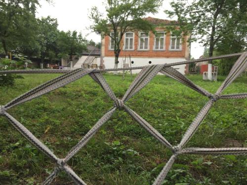 a chain link fence in front of a house at Lazuri Keria Family Guesthouse in Khoni