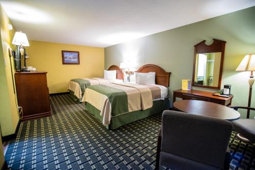 ein Hotelzimmer mit 2 Betten und einem Tisch in der Unterkunft Relax Inn and Suites Kuttawa in Kuttawa