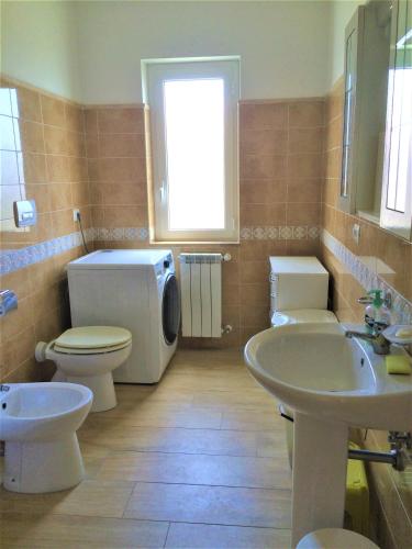 a bathroom with two sinks and a toilet and a window at Villa sul Mare in Belvedere Marittimo
