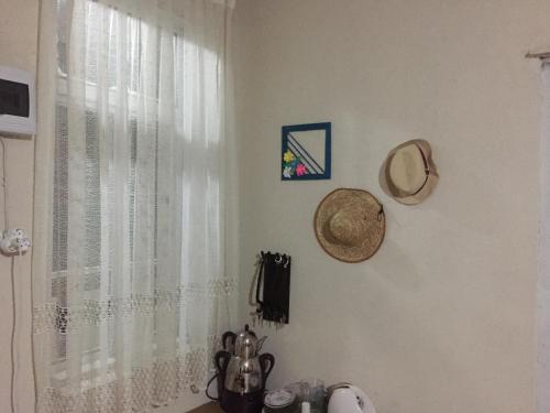 a kitchen with a window with white curtains at Lazuri Keria Family Guesthouse in Khoni