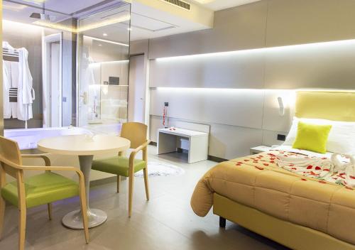 a bedroom with a bed and a table and a bathroom at Hotel Miramare in Marina di Varcaturo