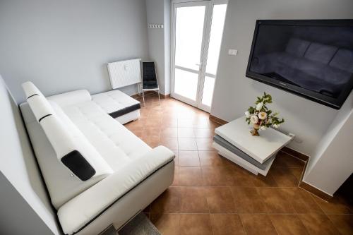 a living room with a white couch and a flat screen tv at Apartament Augustów in Augustów