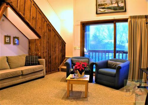sala de estar con 2 sillas y mesa con flores en Great Location 3 bedroom condo, Ski home Whiffletree E8, en Killington