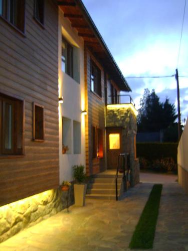 a house with a staircase leading up to a building at Hostería Antu Kuyen in San Carlos de Bariloche