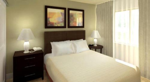 una camera con un letto, due lampade e una finestra di Ledgestone Hotel a Yakima