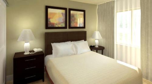 a bedroom with a bed and two lamps and a window at Ledgestone Hotel in Yakima