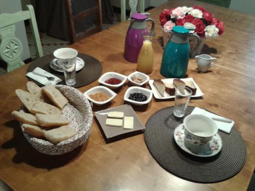 un tavolo con pane e piatti di cibo sopra di La Maison d´Amazone a Mont-Disse