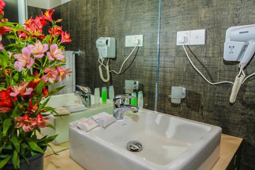 bagno con lavandino, specchio e fiori di Oak Ray Summer Hill Breeze a Nuwara Eliya