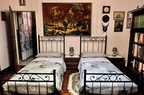 two beds in a room with a painting on the wall at B&B "Il Cantastorie" Casa Molinari-Boldrini - Room & breakfast in Castelfranco Emilia