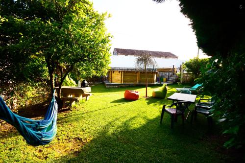 a backyard with a hammock and a table and chairs at Moinho do Prado in Vila Nova de Cerveira