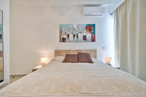 聖朱利安斯的住宿－"Centre Point" Apartment，卧室配有一张大床,墙上挂有绘画作品