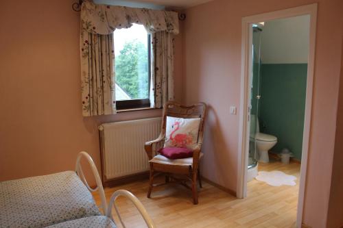 Pokój z krzesłem, łóżkiem i oknem w obiekcie Happy Together w mieście Francorchamps