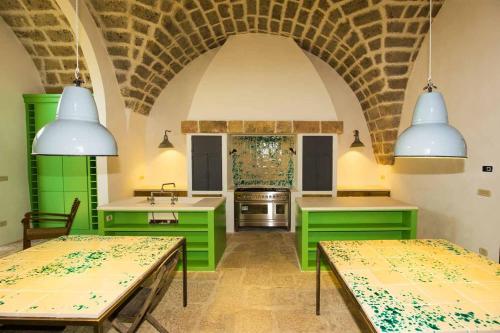 a kitchen with green cabinets and a sink and counters at Masseria Celano in Grottaglie