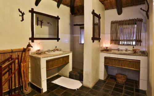 a bathroom with two sinks and a mirror at Tangala Safari Camp in Thornybush Game Reserve