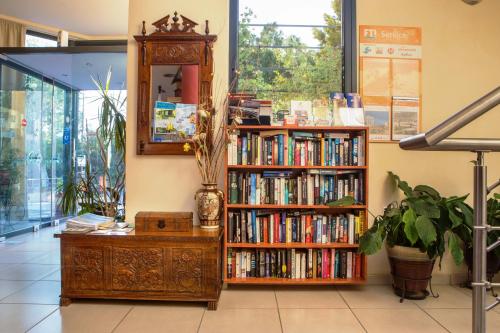 a book shelf filled with books next to a mirror at Aeolian Gaea Hotel in Skala Kallonis
