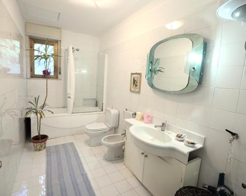 een badkamer met een wastafel, een toilet en een spiegel bij The Patrick in Catania