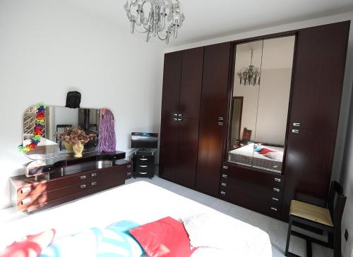 een slaapkamer met een bed, een dressoir en een spiegel bij The Patrick in Catania