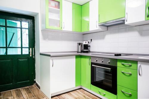 a kitchen with green cabinets and a black door at Bagoly lak in Mátraszentimre