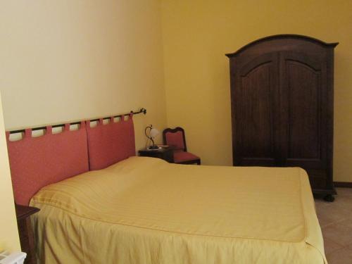 シラクーサにあるL'Arancio e il Limoneのベッドルーム1室(ベッド1台付)、木製キャビネットが備わります。