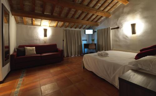 a bedroom with a bed and a couch at villa Resort Tre Castelli in Trecastelli