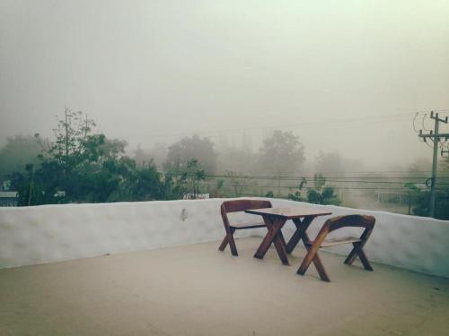 a table and two chairs sitting on a roof at BaanChomJan @ Suanphung in Suan Phung